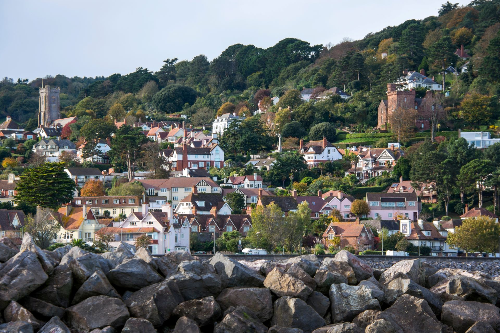 a hillside view of houses, buildings, church and trees in Minehead