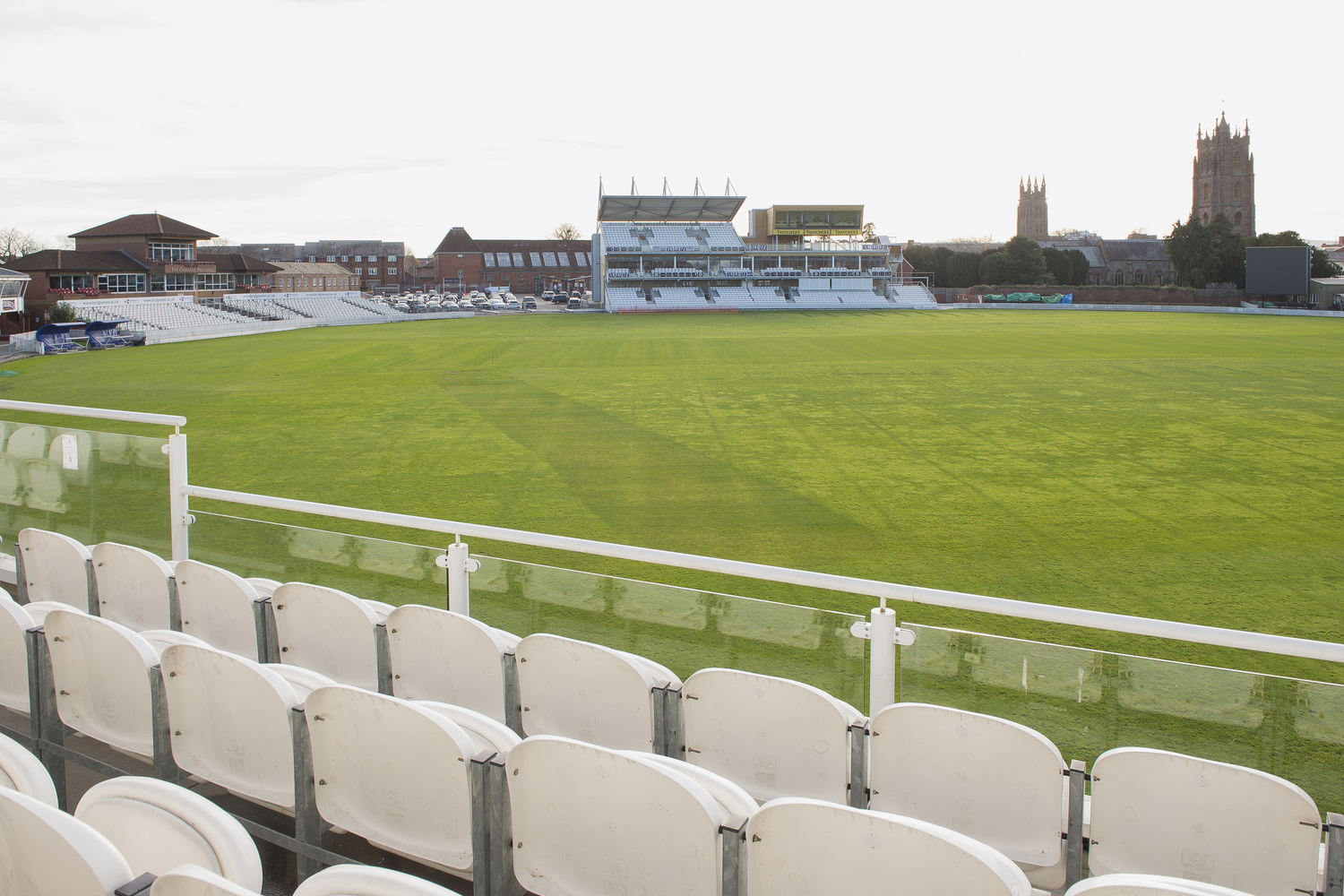A view of Somerset Country Cricket ground from a row of white seats.