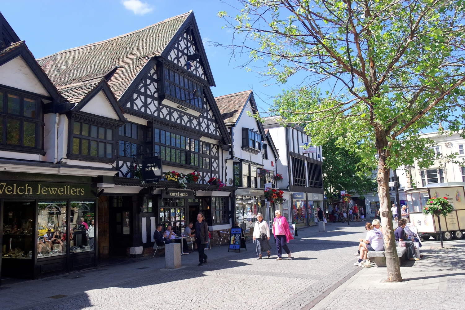 A Tudor building in Taunton town centre, with people walking by.