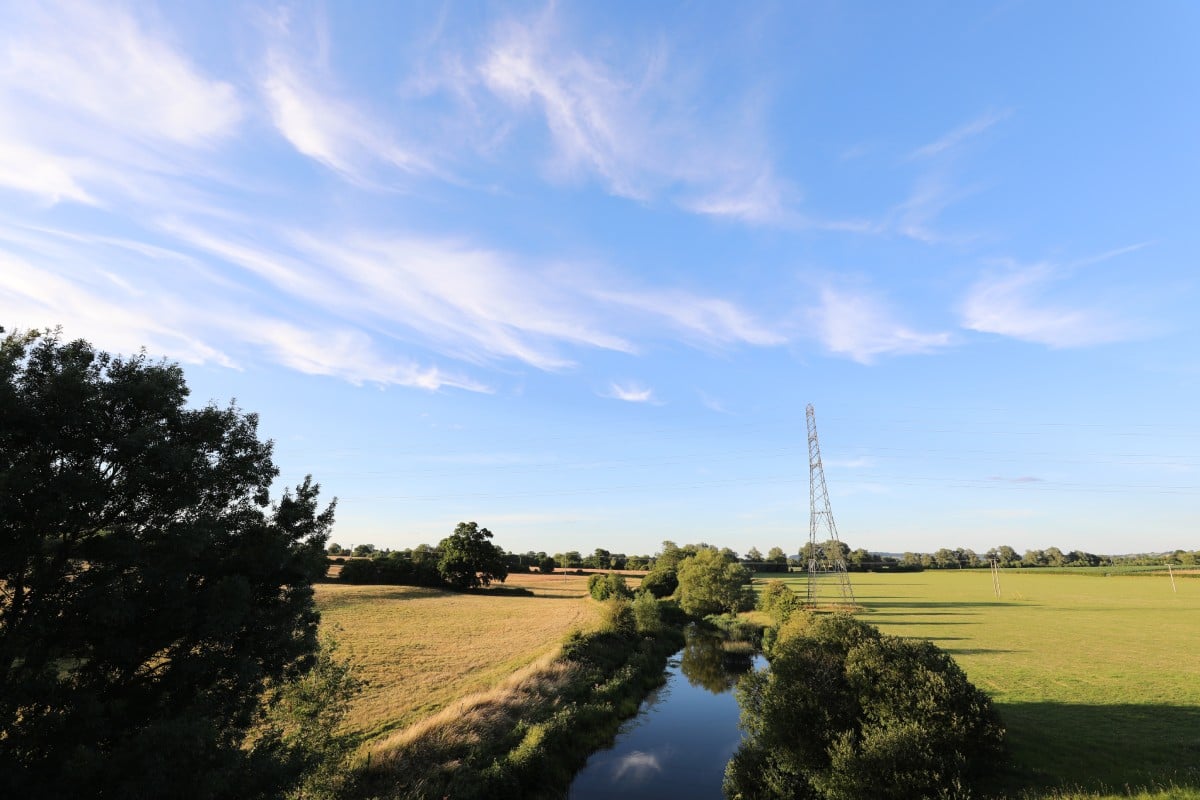 a river running through a grassy area in the countryside of Wiltshire
