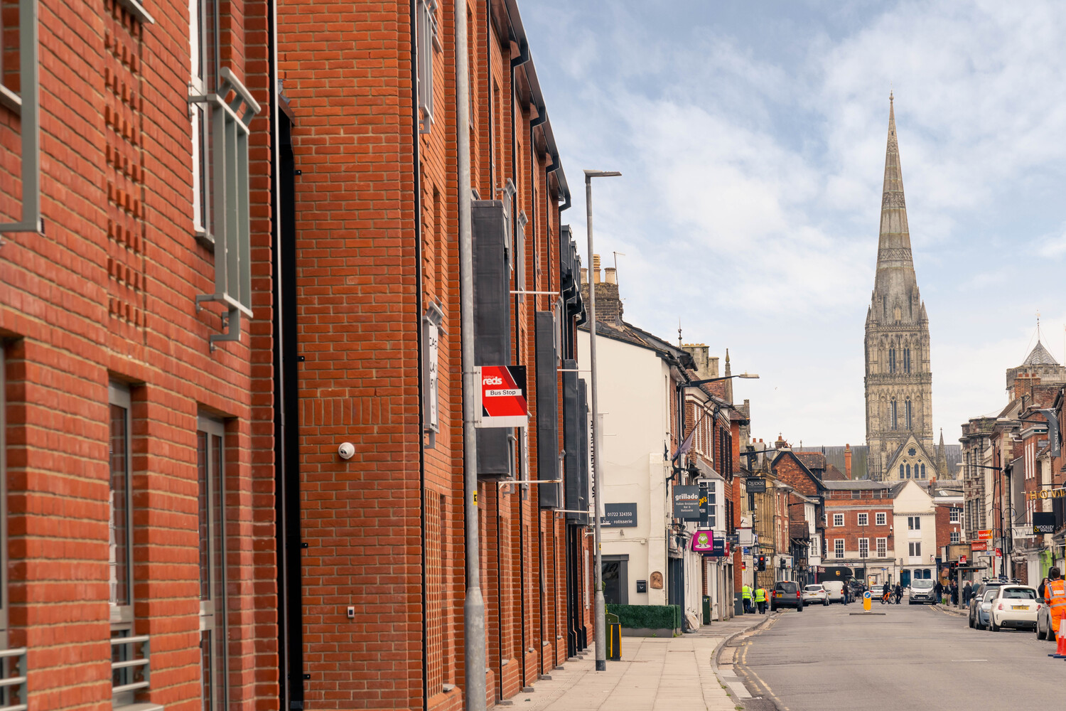 A bus stop outside of Monument Place, with the cathedral in the background.