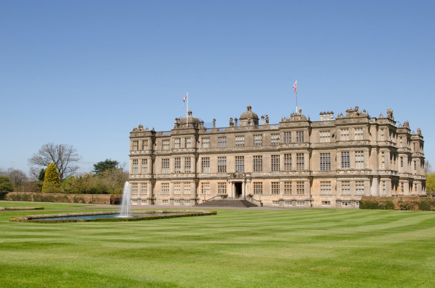 A lawn featuring a water fountain in front of Longleat House.