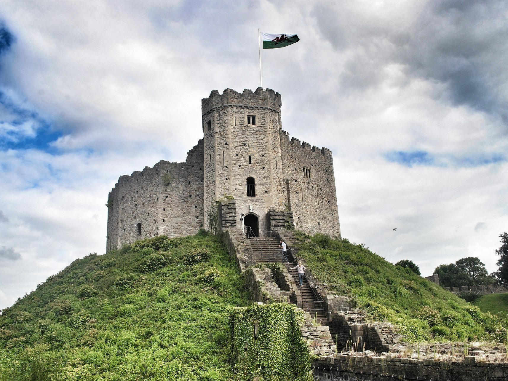 a stone castle on a hill with Cardiff Castle in the background