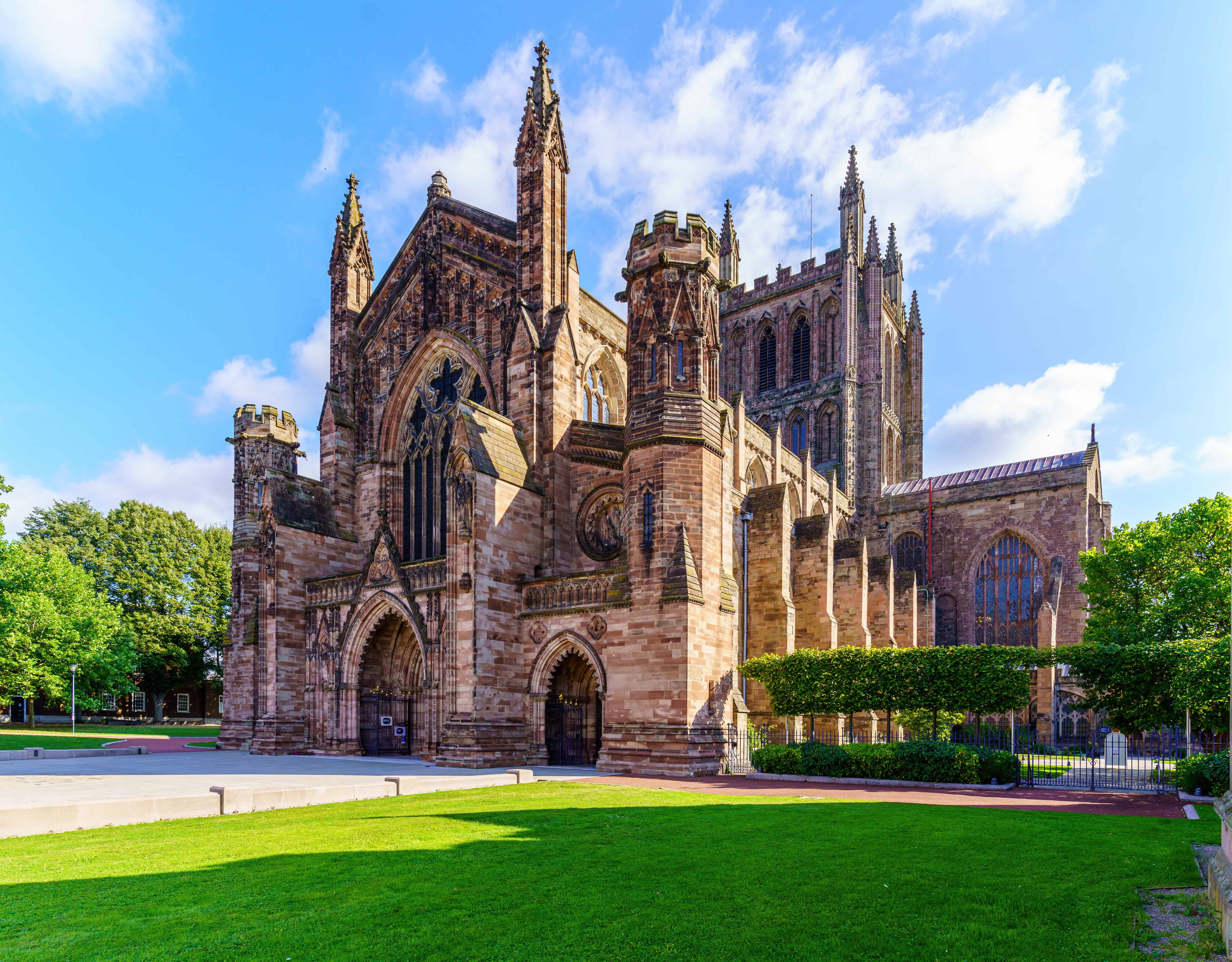 a large brick building with towers with Hereford Cathedral in the background