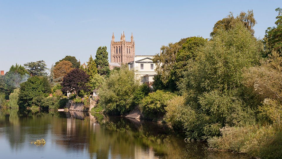 a river with trees and a castle in the background