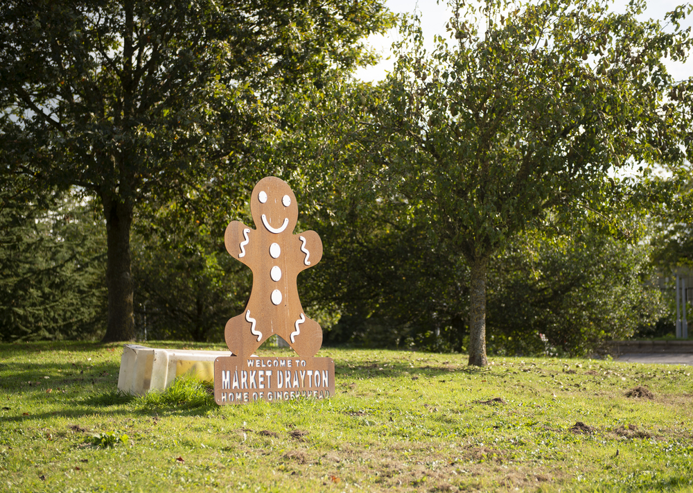 Welcome sign in the shape of gingerbread biscuit welcoming drivers to Market Drayton.