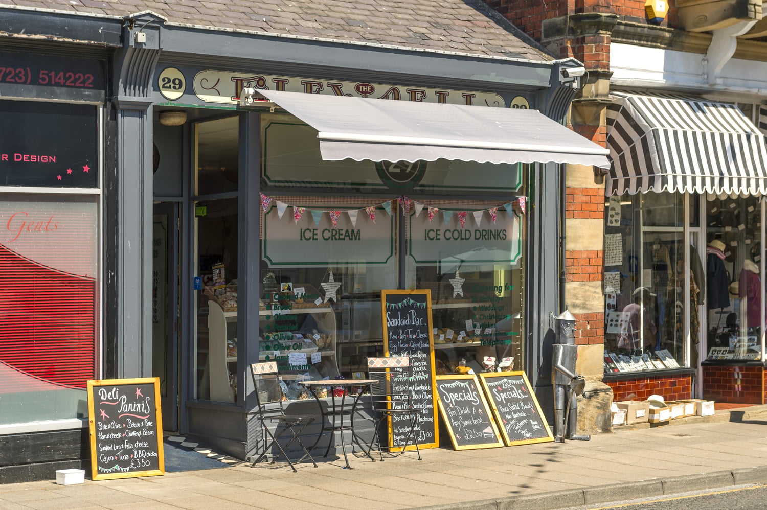 A storefront for an ice cream shop in Filey, featuring several chalkboard signs advertising products.