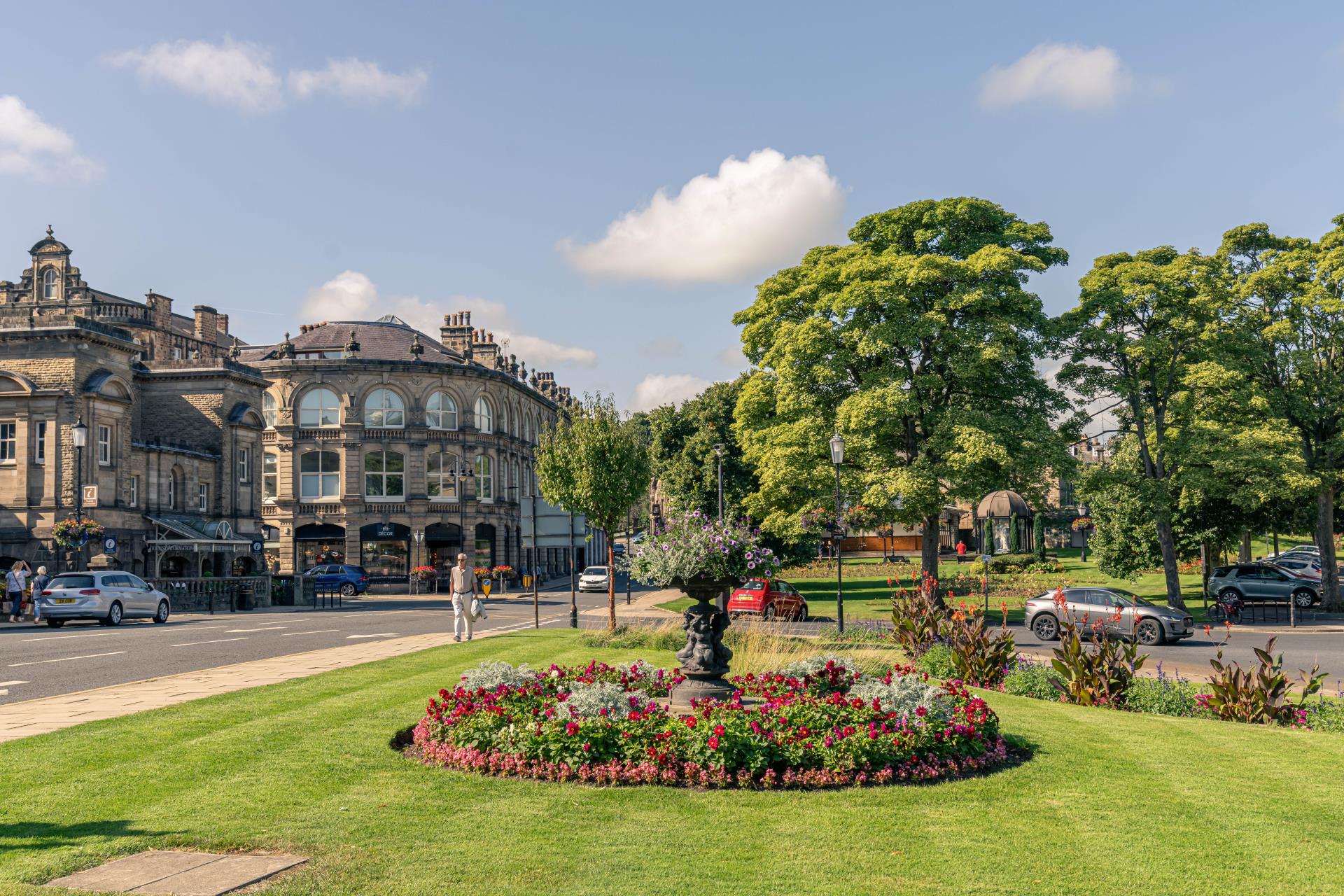 a large building with trees and flowers in front of it