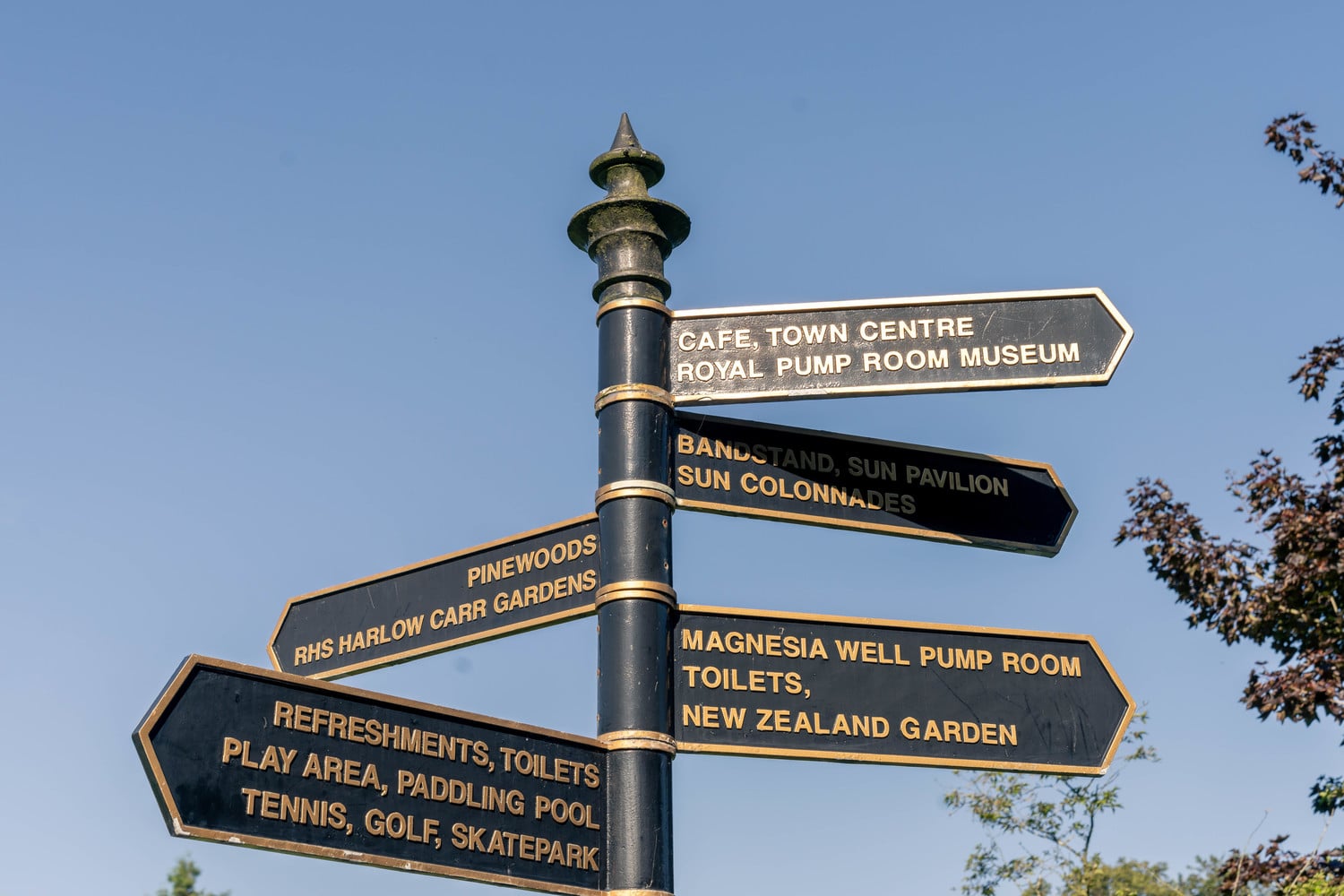 A sign post in Harrogate pointing in multiple directions to different amenities and attractions.
