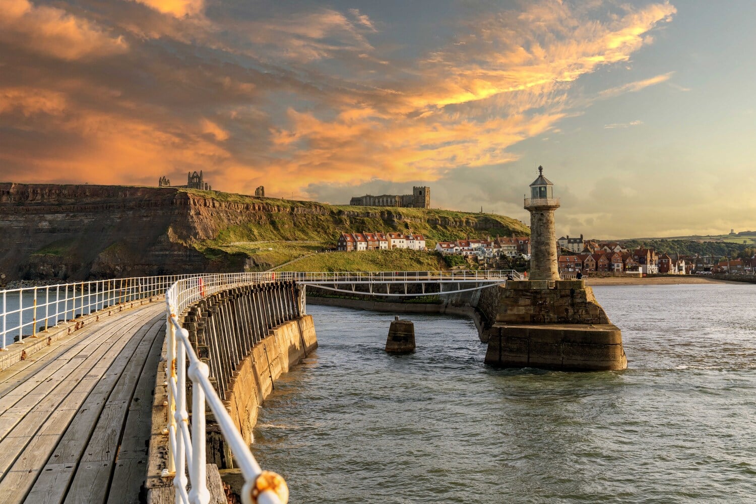 A sunset on the pier at Whitby, overlooking the lighthouse and the Abbey.