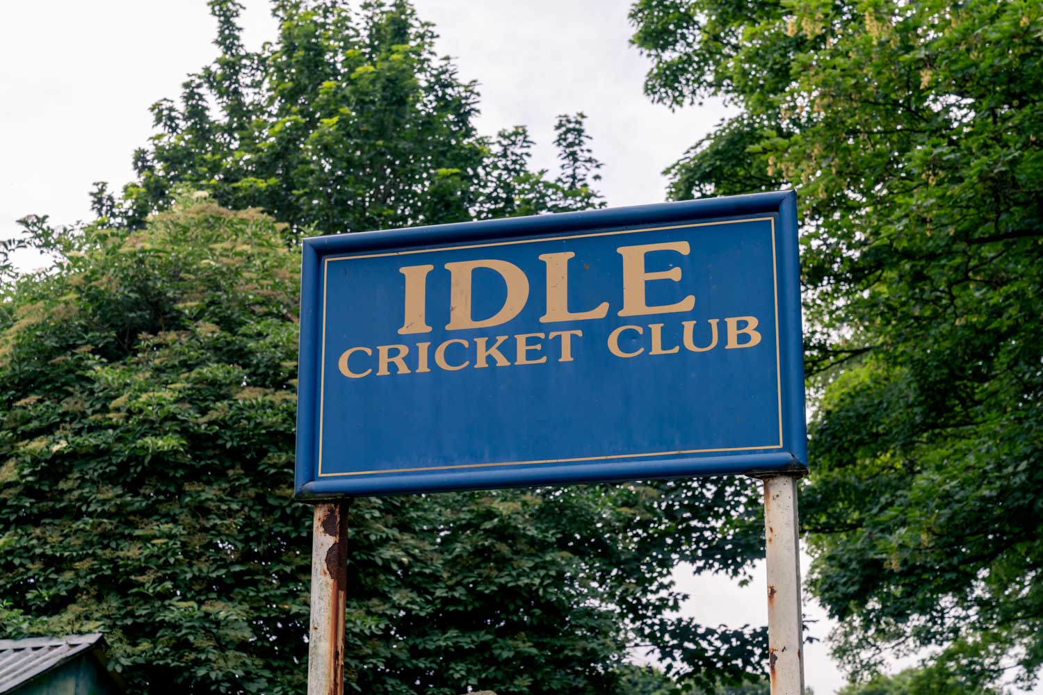 a blue sign in front of trees