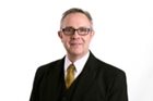 a man wearing glasses and a suit