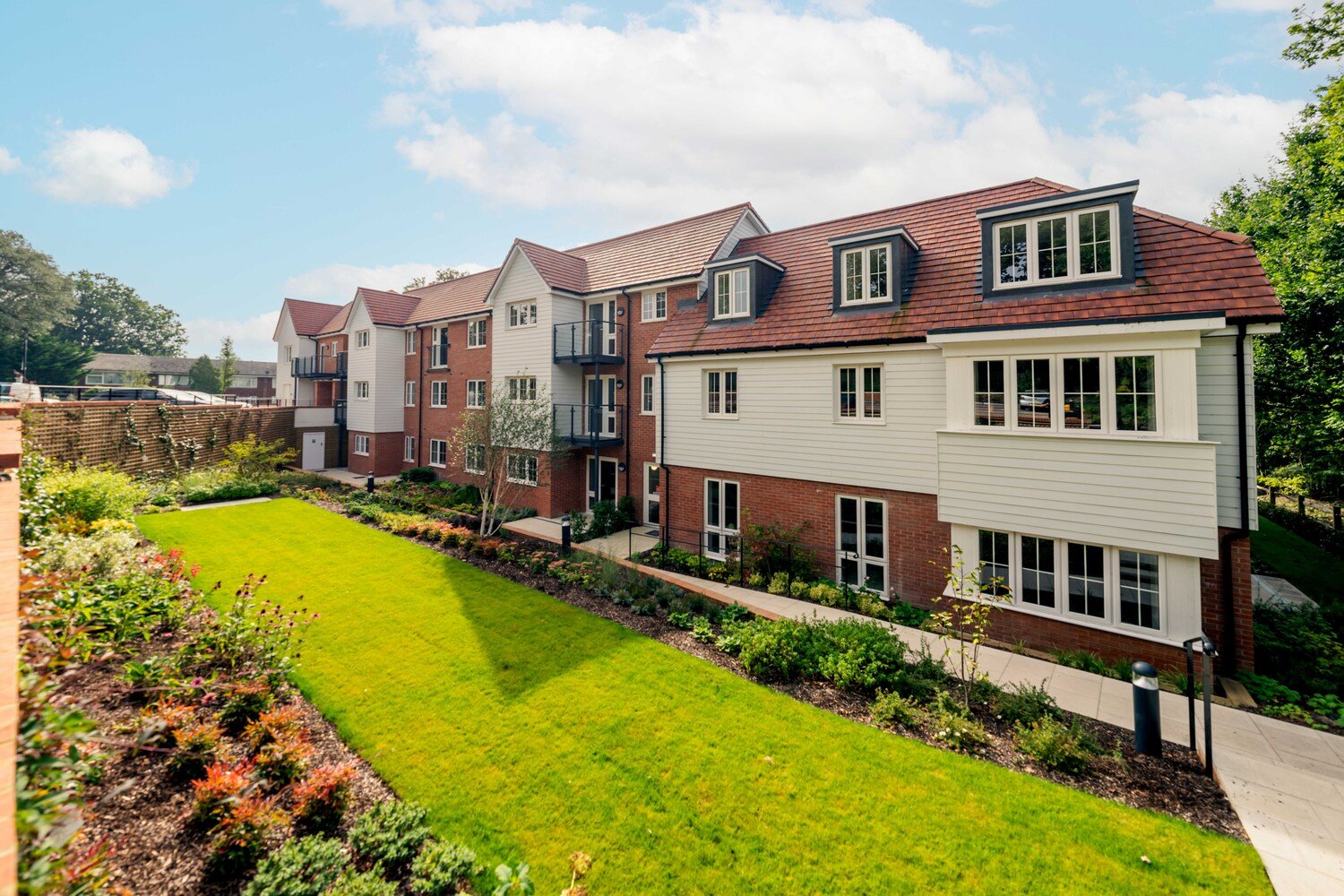 Retirement apartments at a McCarthy Stone development, overlooking a large communal garden.