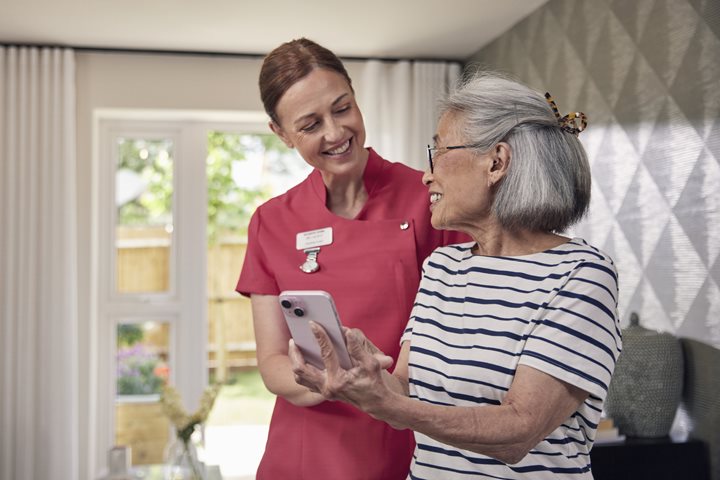 Older person with staff member in a McCarthy & Stone supported living apartment.