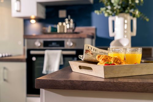 a kitchen counter with a tray of food and a glass of juice