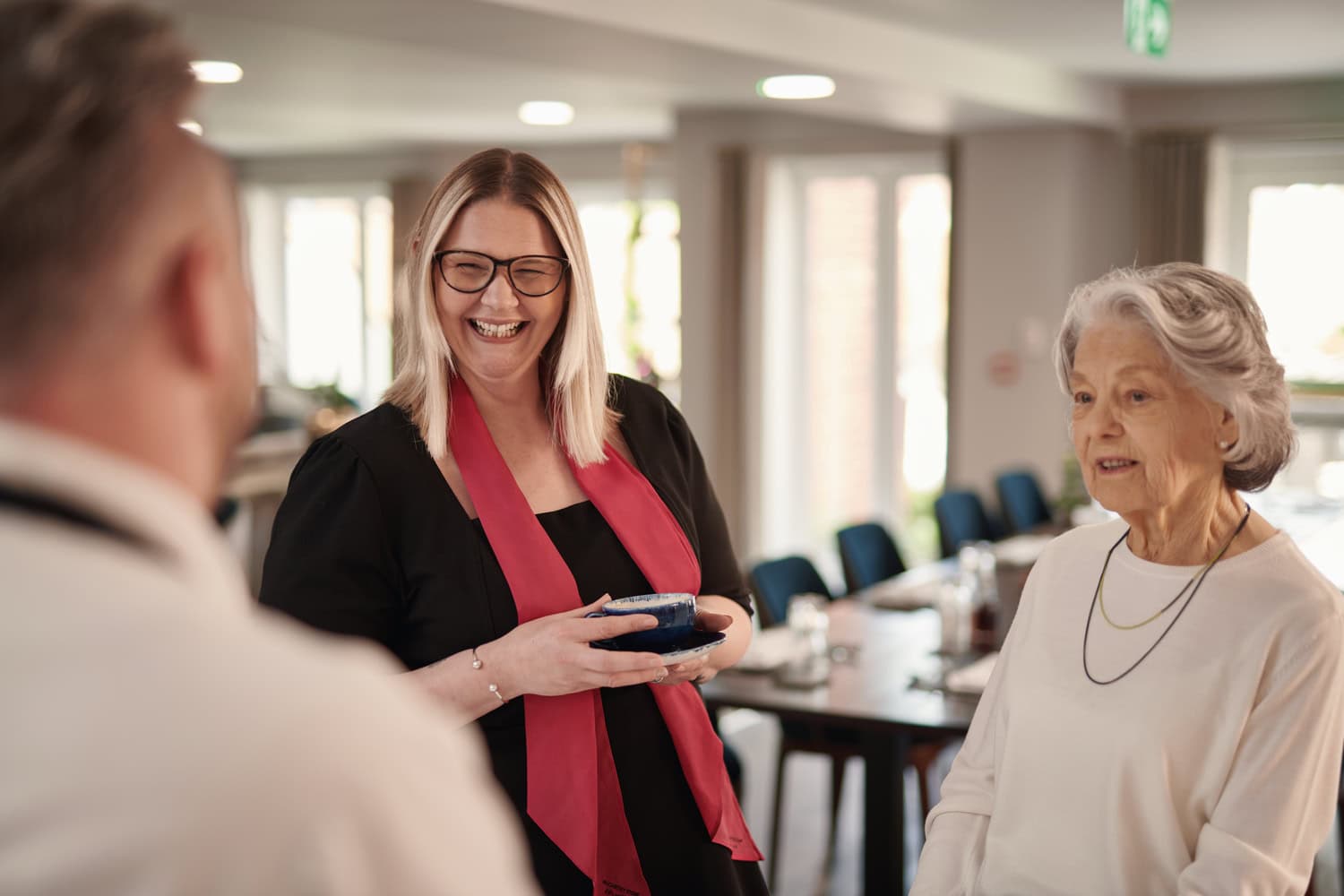 A member of the McCarthy Stone team conversing with two senior residents at a retirement living community