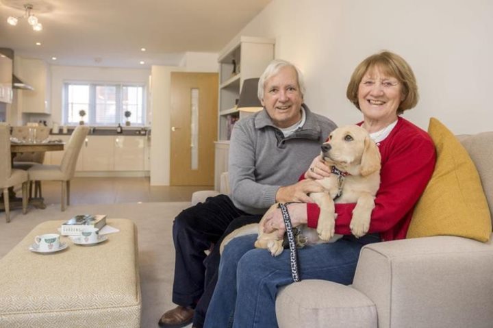 a couple of women sitting on a couch with a dog