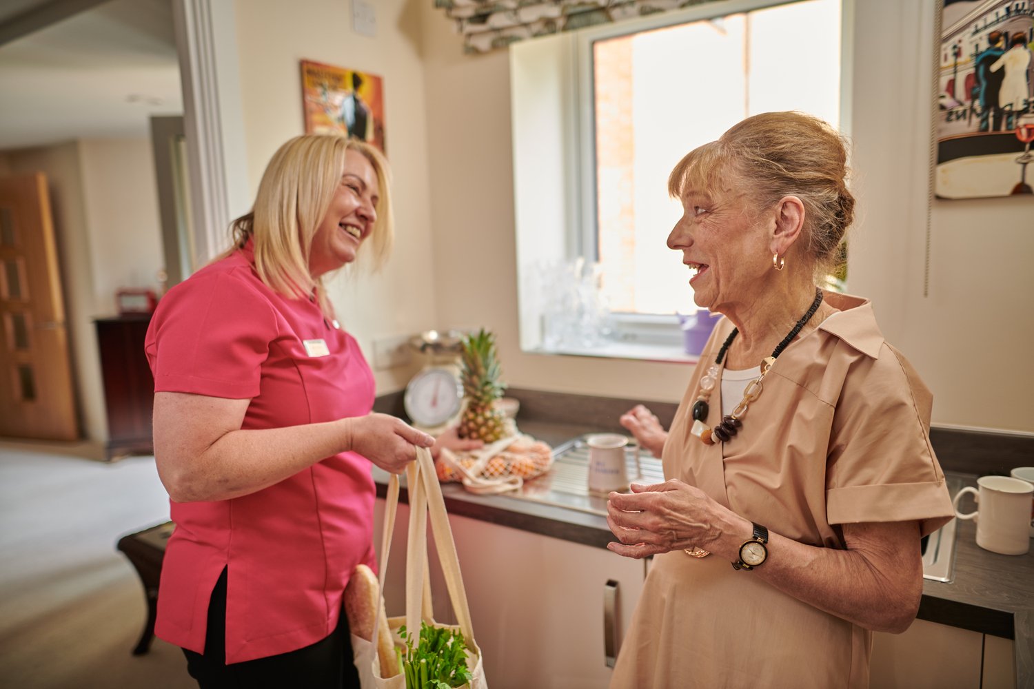 A staff member assisting a homeowner at a McCarthy Stone development with shopping