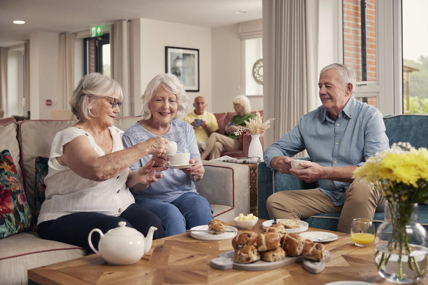 A group of older people enjoy life in their retirement apartment at a Retirement Living PLUS development by McCarthy Stone