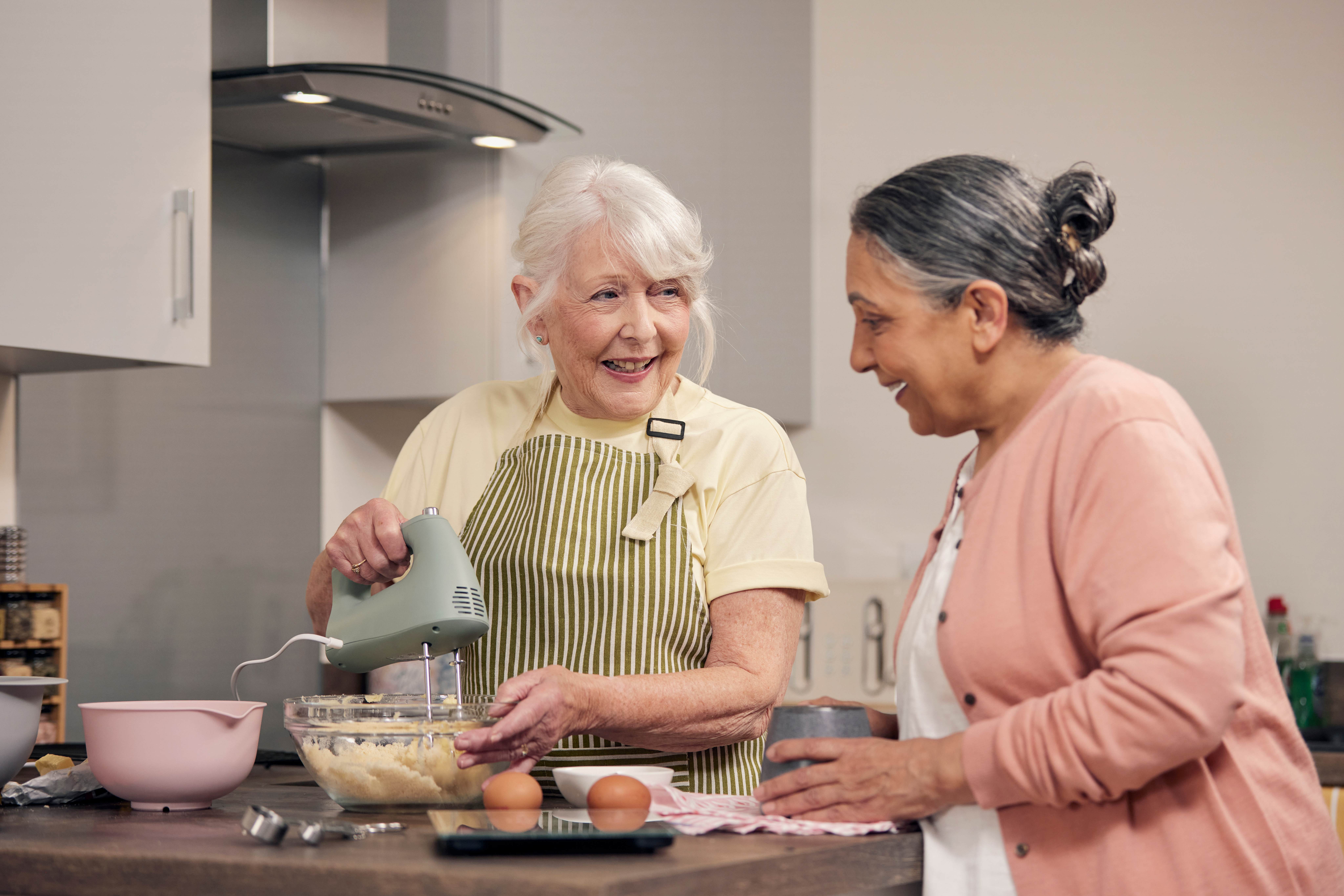 happy retirees cooking in their McCarthy Stone senior living apartment.