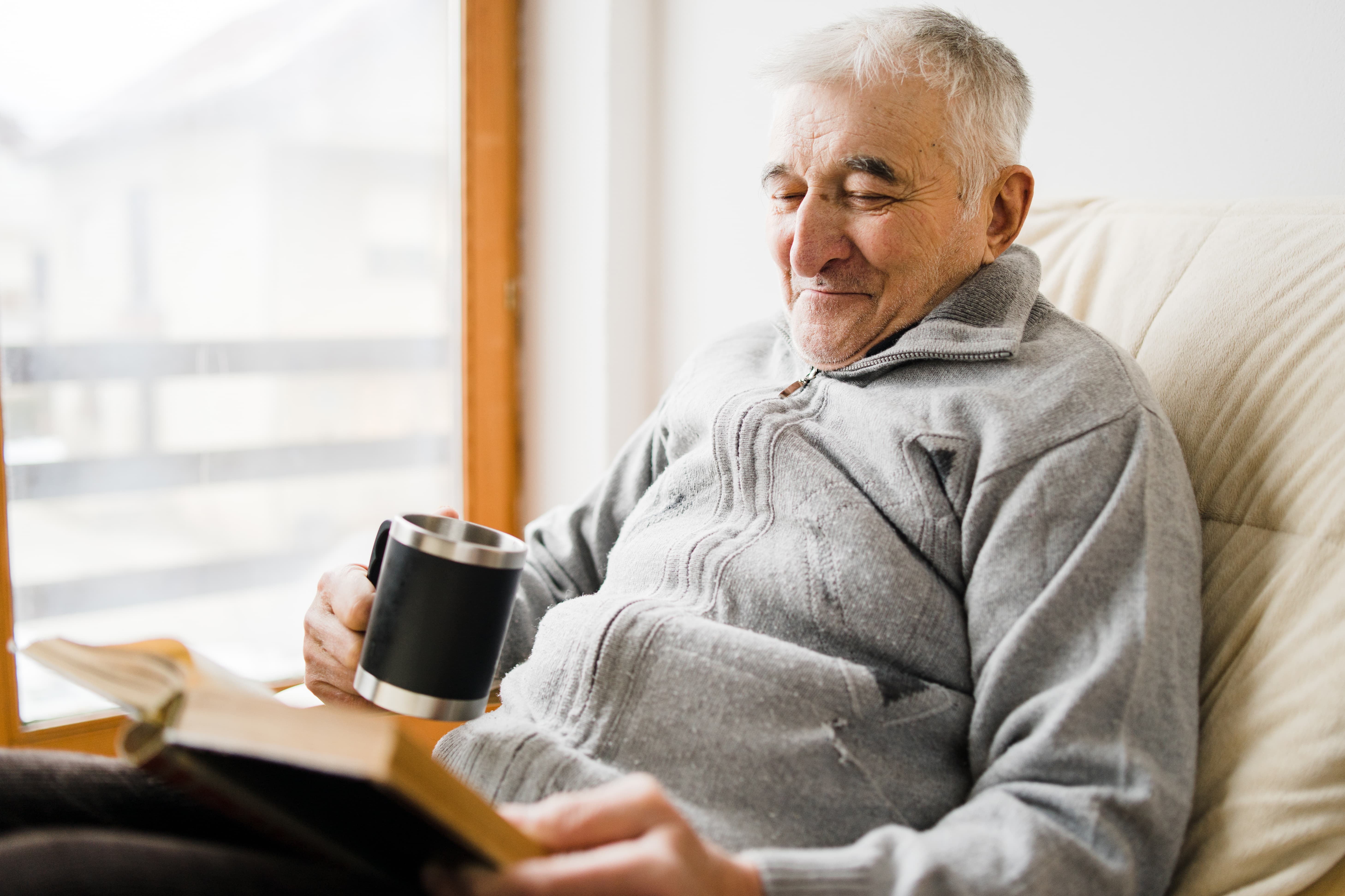 a man sitting on a couch and reading a book