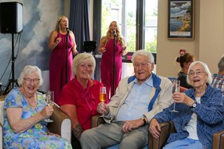 a group of people sitting on a couch holding wine glasses